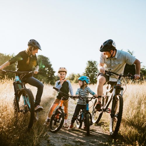 A father and mother ride mountain bikes together with their two small children.  A fun way to spend time together and exercise while on vacation in the Seattle, Washington area.